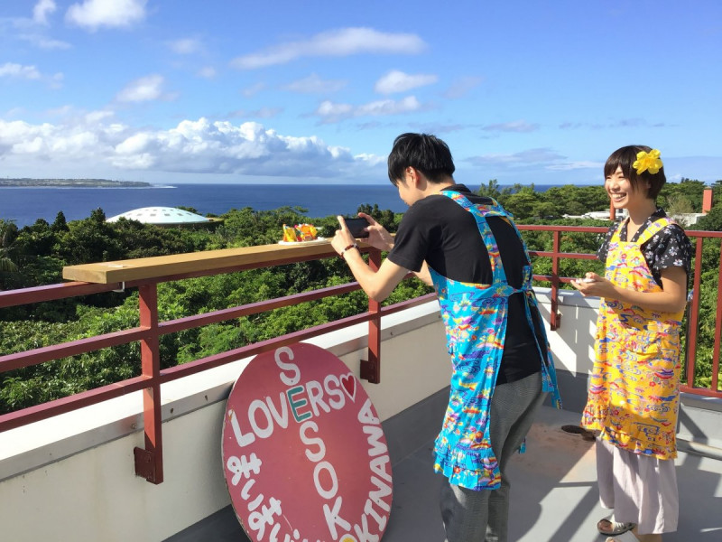 海をバックにシーサーと写真撮影